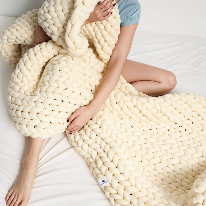 Close-up of a soft, handwoven chunky knit throw blanket, highlighting the cozy texture and warmth.