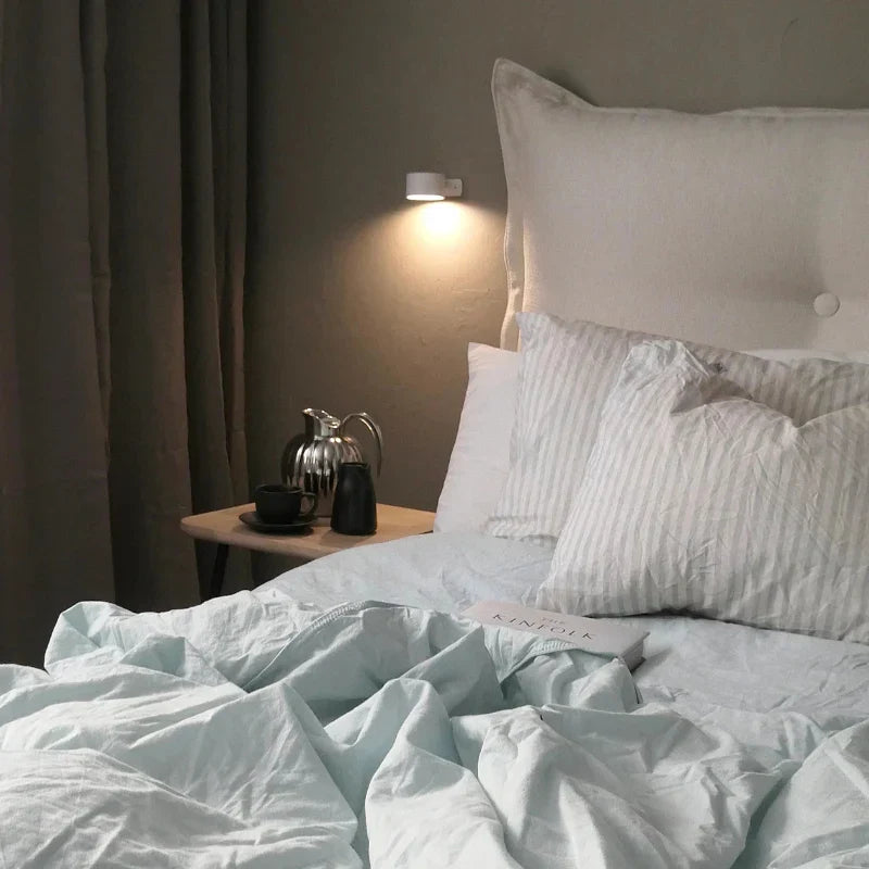 Modern rotating LED wall light, rechargeable, perfect for creating cozy bedroom ambiance.