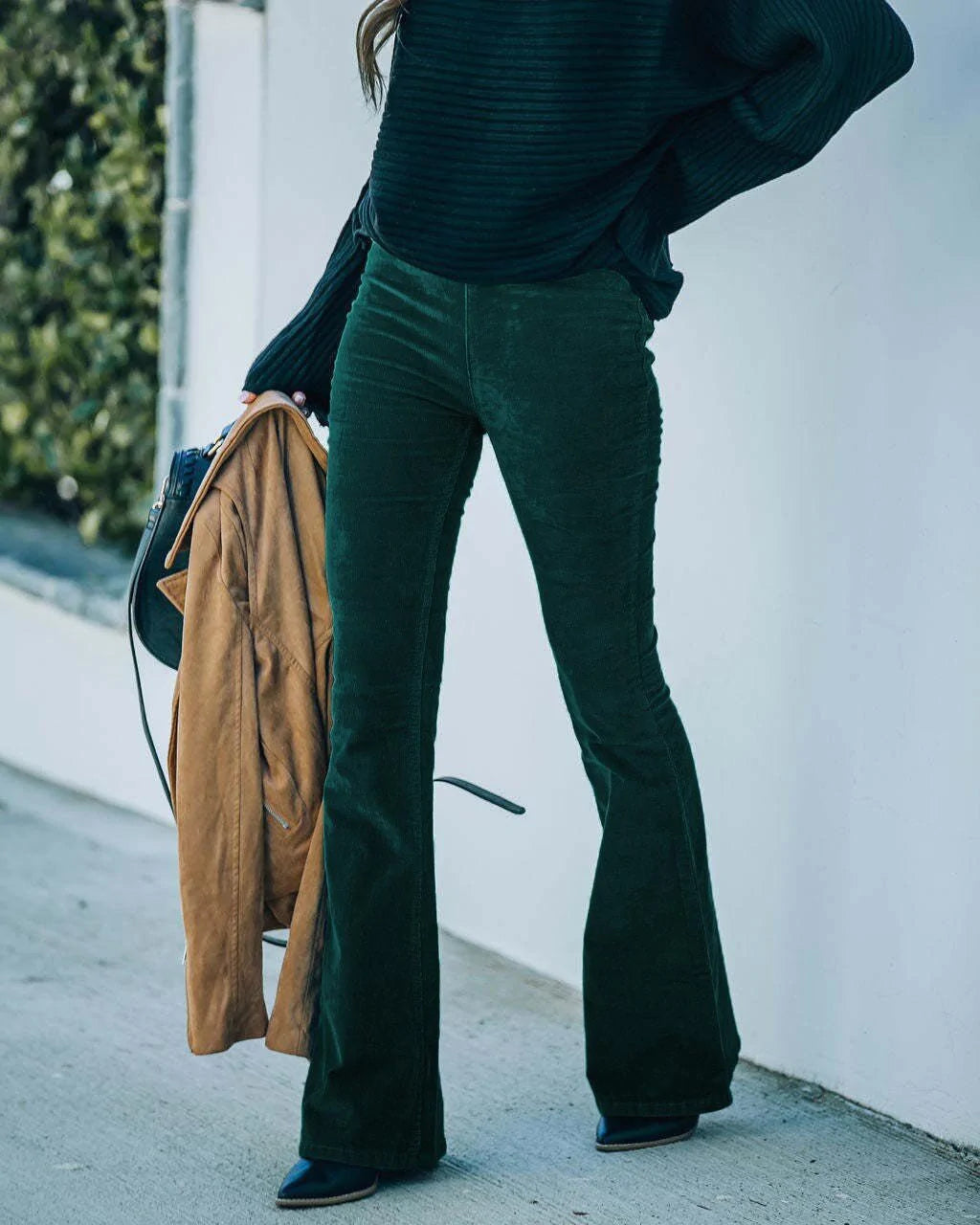 Detailed shot of women's high-waist corduroy flare trousers, showcasing texture and fit.
