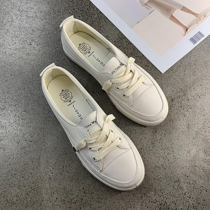 Trendy white casual women's sneakers with a round toe and lace-up closure for versatile styling.