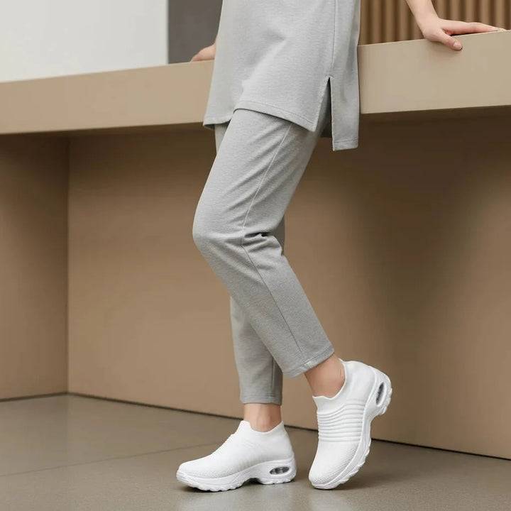 Stylish White women's slip-on casual sneakers, offering arch support for versatile wear.