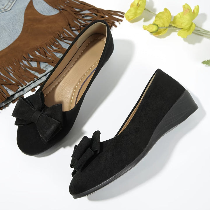 Elegant nude women's wedge flats, round toe slip-ons with a delicate bow for comfortable wear.