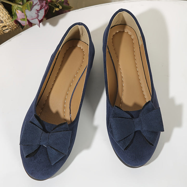 Rich brown faux leather wedge flats, comfortable women's slip-on shoes with a charming bow accent.