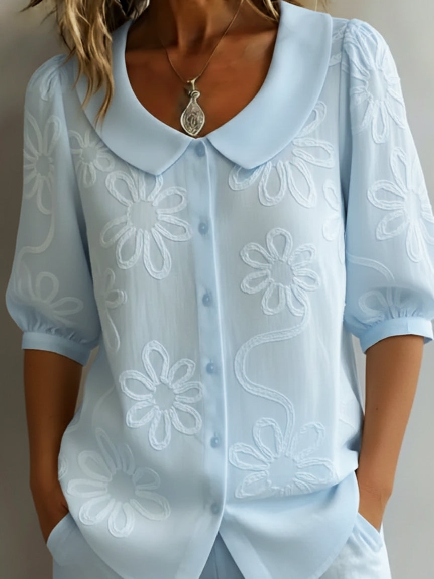 Elegant women's half-sleeve floral blouse. Features a charming Peter Pan collar, ideal for casual wear.