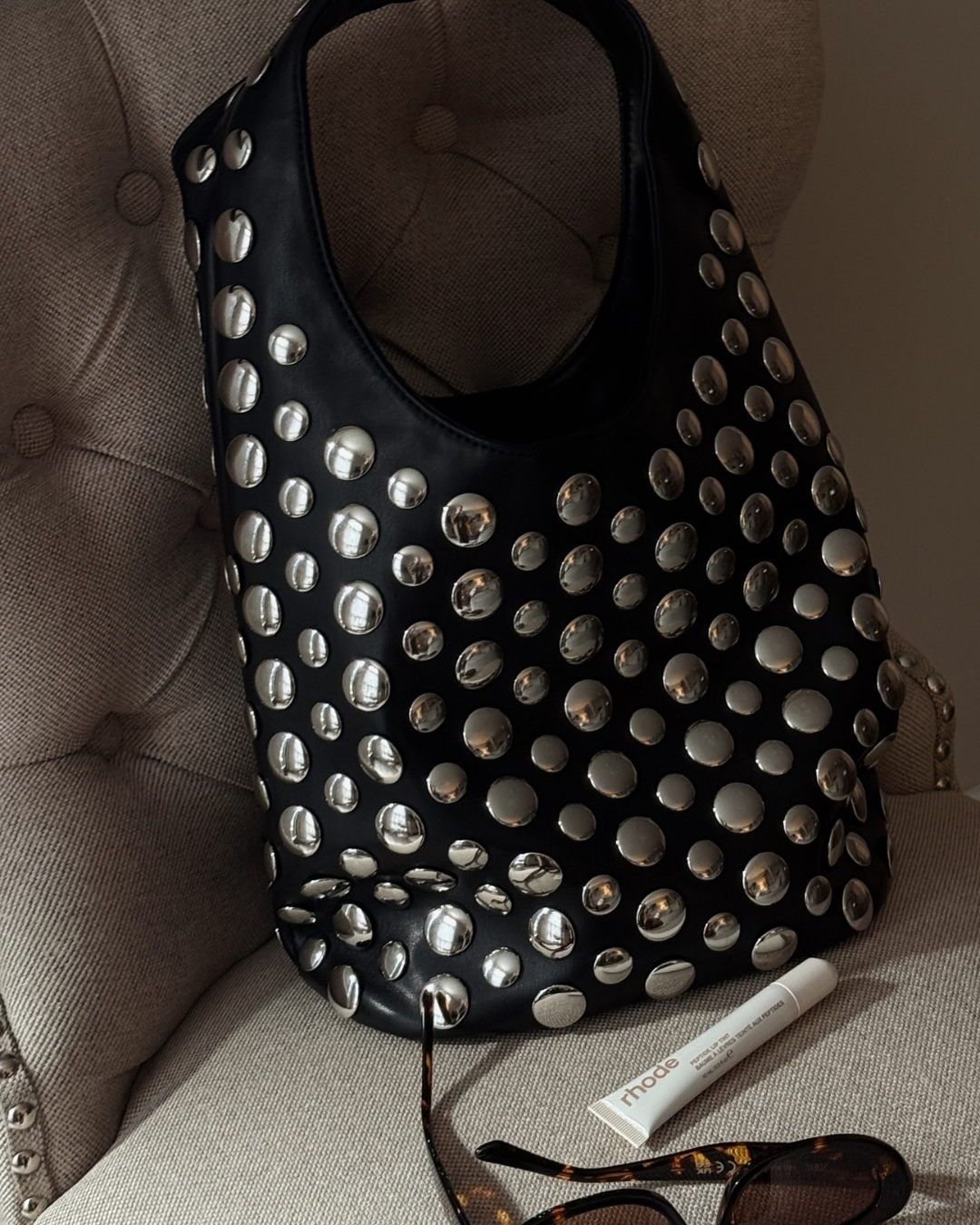 Elegant black studded shoulder bag for women, featuring rivet details. A versatile fashion accessory and evening bag.