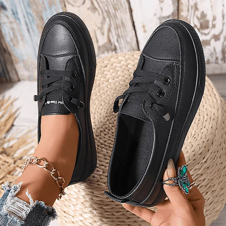 Black women's fashionable low profile flat lace-up sneakers, ideal for versatile everyday walking.