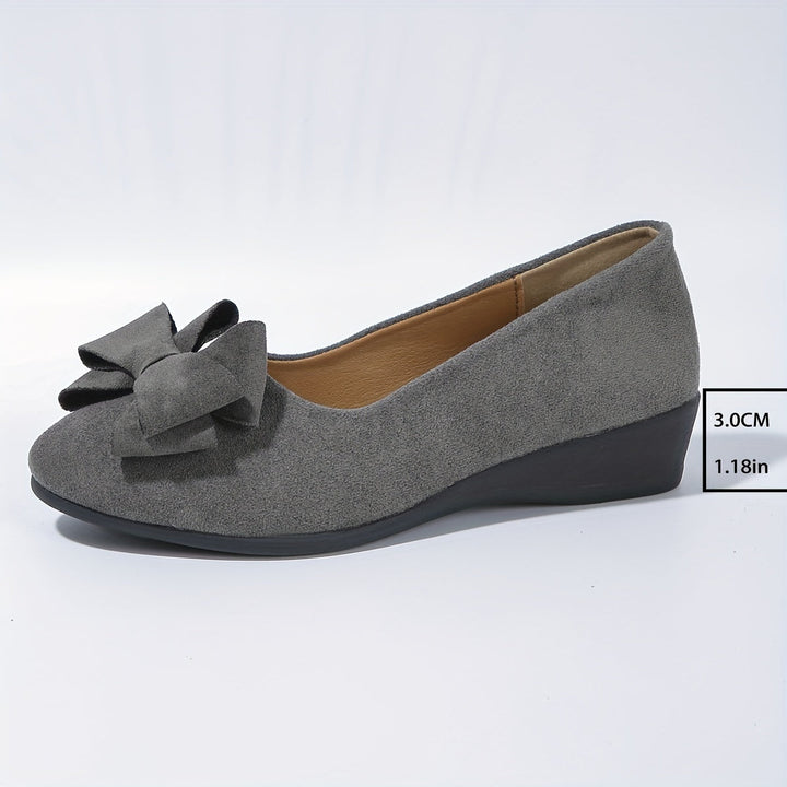 Crisp white women's wedge ballet flats, versatile slip-on style with classic bow, perfect for summer.