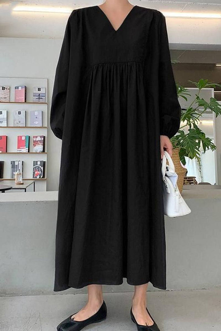 Elegant women's V-neck midi dress featuring loose long balloon sleeves and a relaxed A-line fit. Chic style.