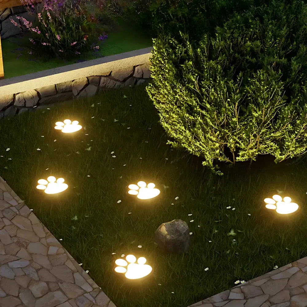 Charming Paw Print Solar Path Lights illuminating a garden pathway, eco-friendly outdoor decor.