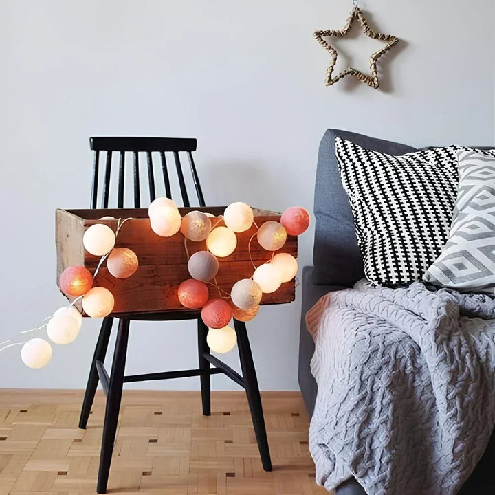 Nvroome Lights warm LED cotton ball string lights in a vase, creating a cozy table centerpiece.