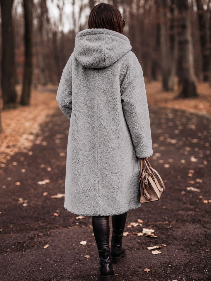 Stylish women's winter coat with a hood, knee-length for warmth and a chic, cozy look.