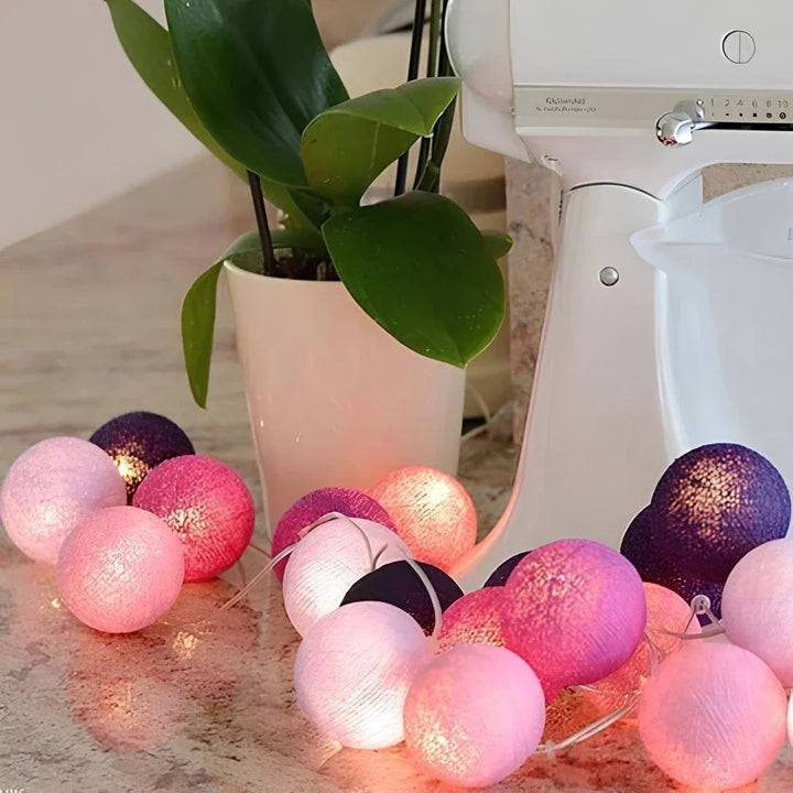 Indoor lighting: warm LED cotton ball string lights accentuating a window frame.