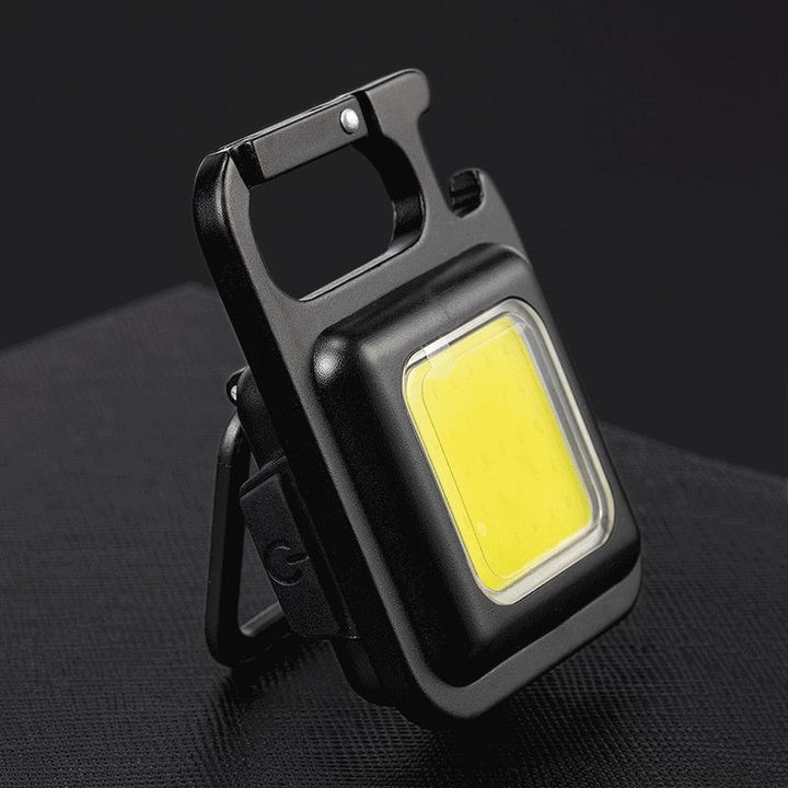 Unisex rechargeable keychain flashlight with LED & COB lights, multi-tool, and bottle opener. Portable EDC light.