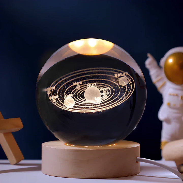 Unisex 3D galaxy LED crystal ball desk lamp, glowing vividly on a wooden base. Ideal unique gift or night light.