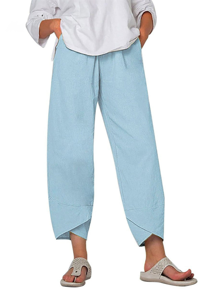Back view of woman in relaxed fit linen harem trousers, wide leg casual pants with elastic waist.