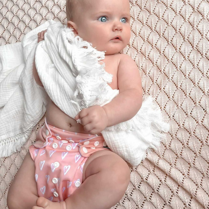 Pack of various printed eco-friendly cloth diapers for sustainable baby care.