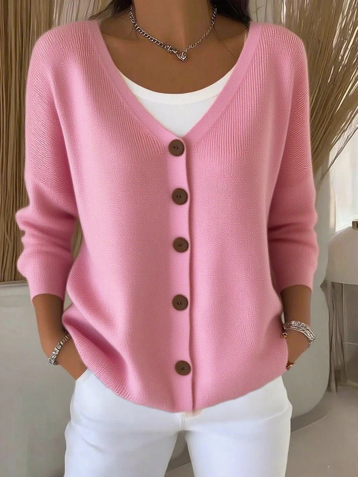 Warm women's knit cardigan featuring a V-neck, buttons, and long sleeves. Perfect comfortable chic knitwear.
