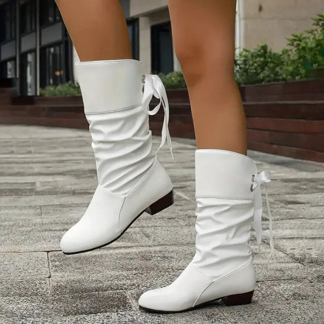 Women's slouchy lace-up block heel ankle boots modeled, showcasing their trendy design & casual footwear appeal.