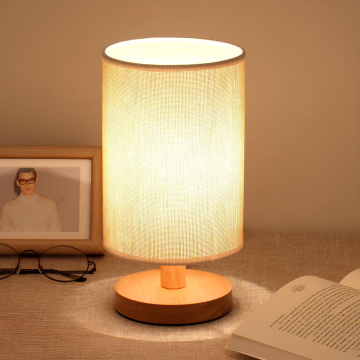 Close-up of the Organic Glow Table Lamp, showcasing its smooth wood base and textured fabric shade detail.