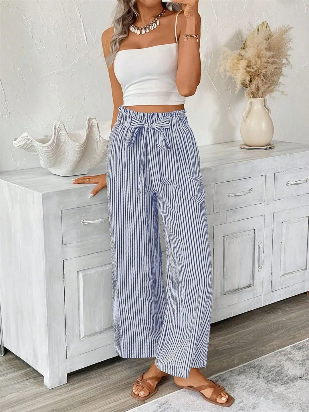 Women's flowy wide leg striped pants with pockets and a flattering paperbag waist.