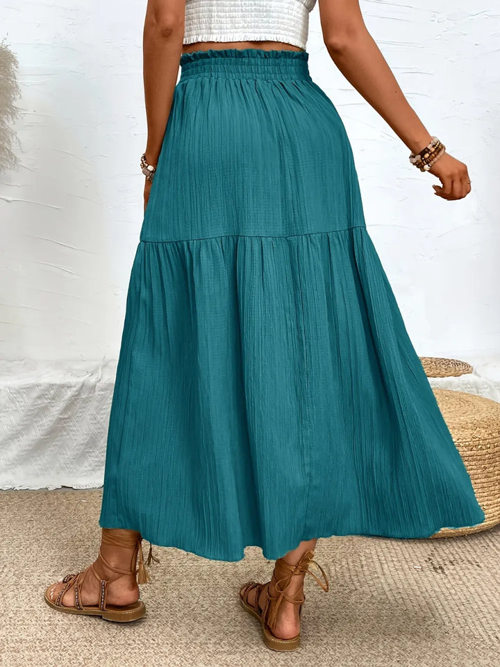 Elegant women's tiered midi skirt featuring a high slit, versatile for casual or dressy summer wear.