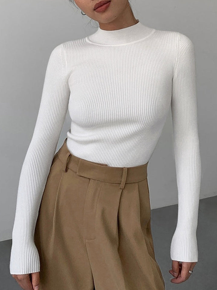 Close-up of a women's ribbed high neck top, highlighting texture. Chic long sleeve sweater for versatile wear.
