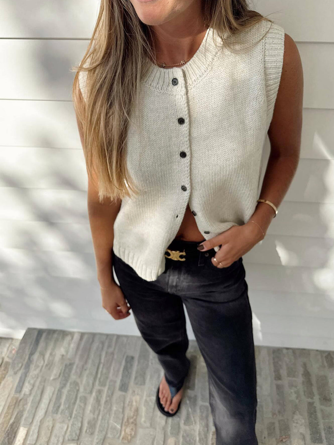 Chic button-up sweater vest for women, a modern sleeveless layering piece for versatile transitional fashion.