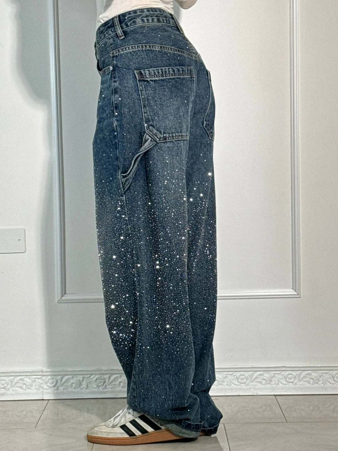 Stylish women's shiny jeans with a balloon leg and carpenter details. Relaxed fit bottoms.