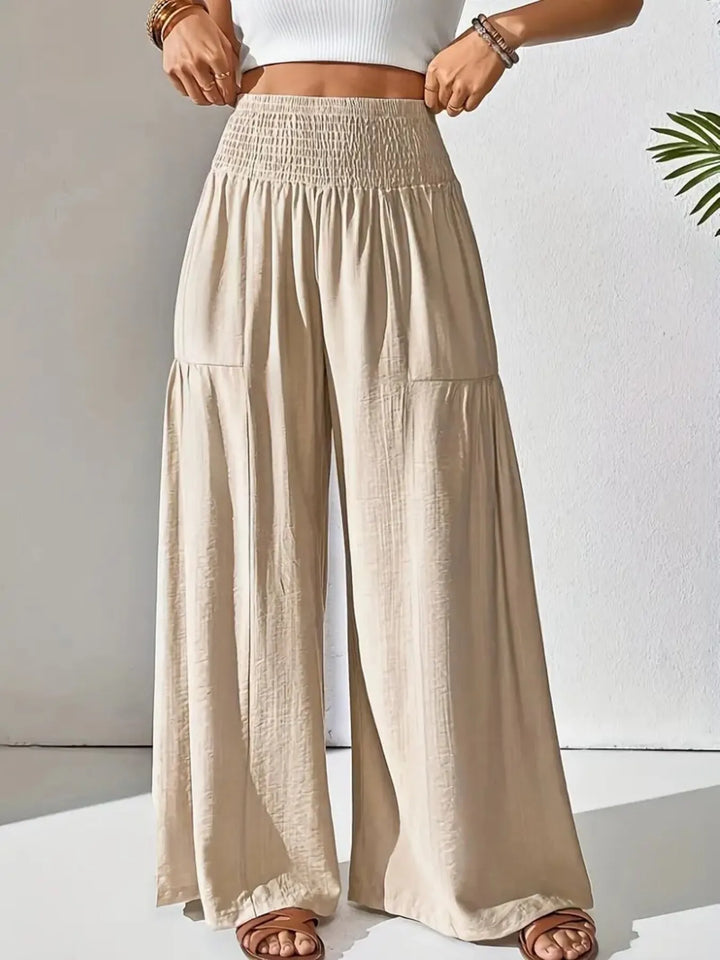 Flowy wide leg pants for women with smocked waist, ideal for comfortable travel & summer style.