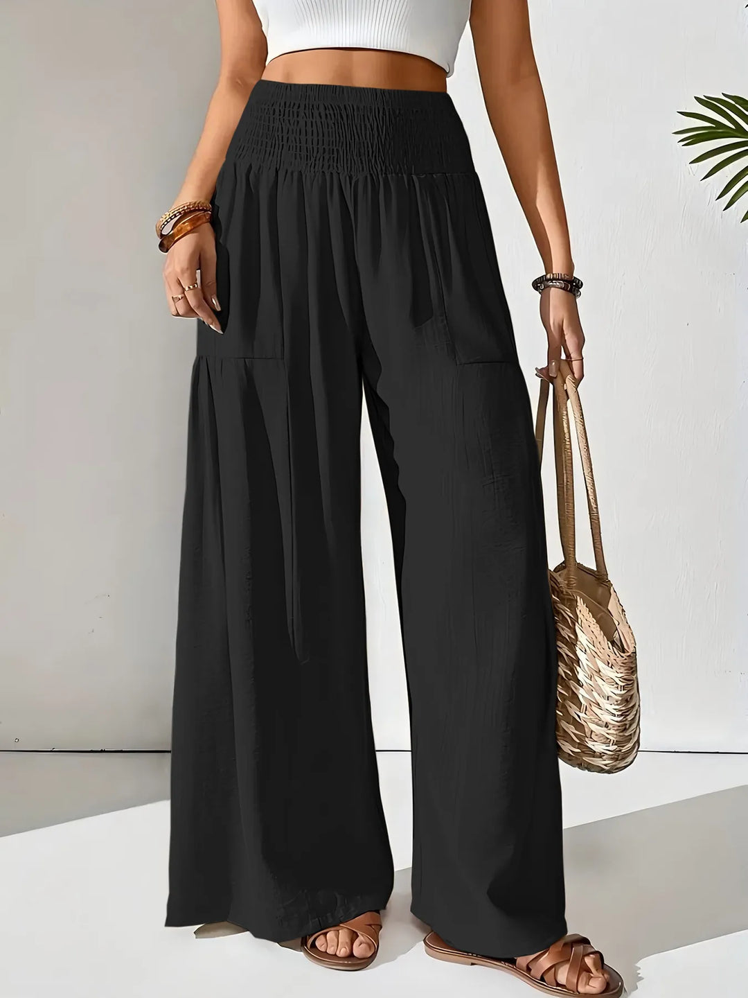 Woman wearing comfortable smocked waist wide leg pants; ideal for relaxing, casual summer days.