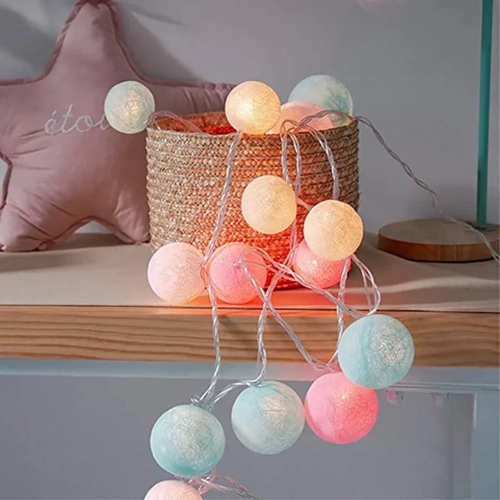 Warm LED garland of cotton balls enhancing a bookshelf, perfect for home and room decor.