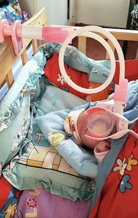 Baby's hands-free bottle holder attached to a crib, facilitating independent feeding for newborns at home. Nursery gear essential.