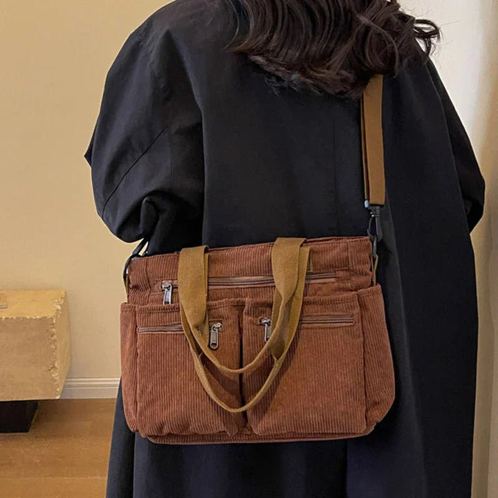 Chic women's corduroy tote bag converts to shoulder or crossbody. Multi-pocket design for stylish daily use.