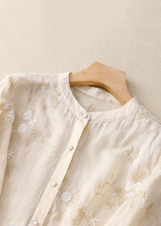 Delicate floral embroidery on a sheer, layered women's blouse. Elegant and airy for warm weather fashion.