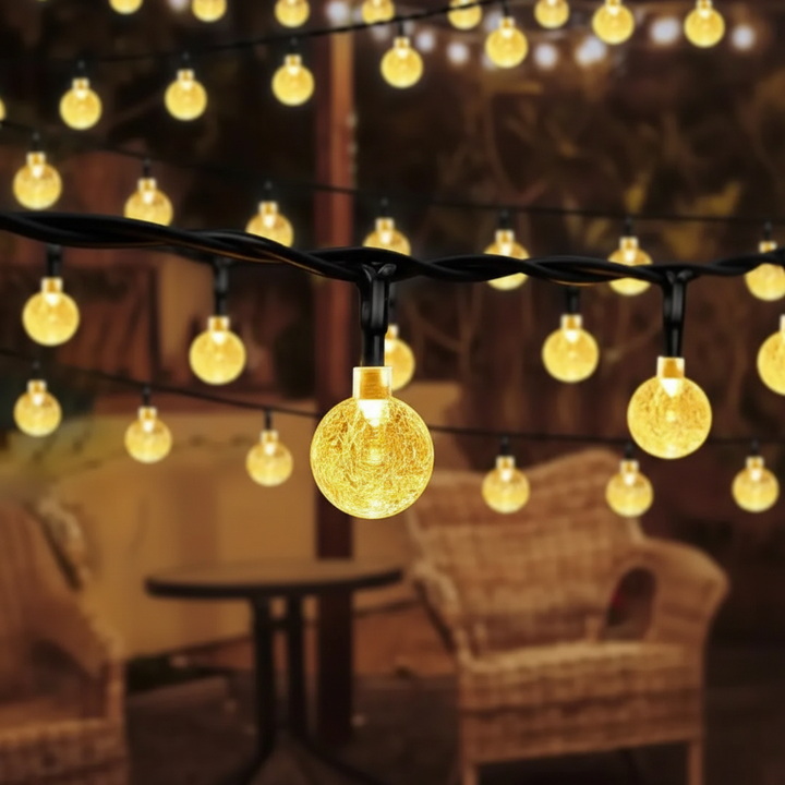 Decorative WeatherGlow solar globe string lights strung across a patio, adding a beautiful glow to outdoor living spaces.