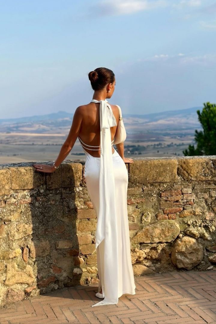 Sophisticated women's pearl wedding guest maxi dress, halter neck, open back, formal evening wear.