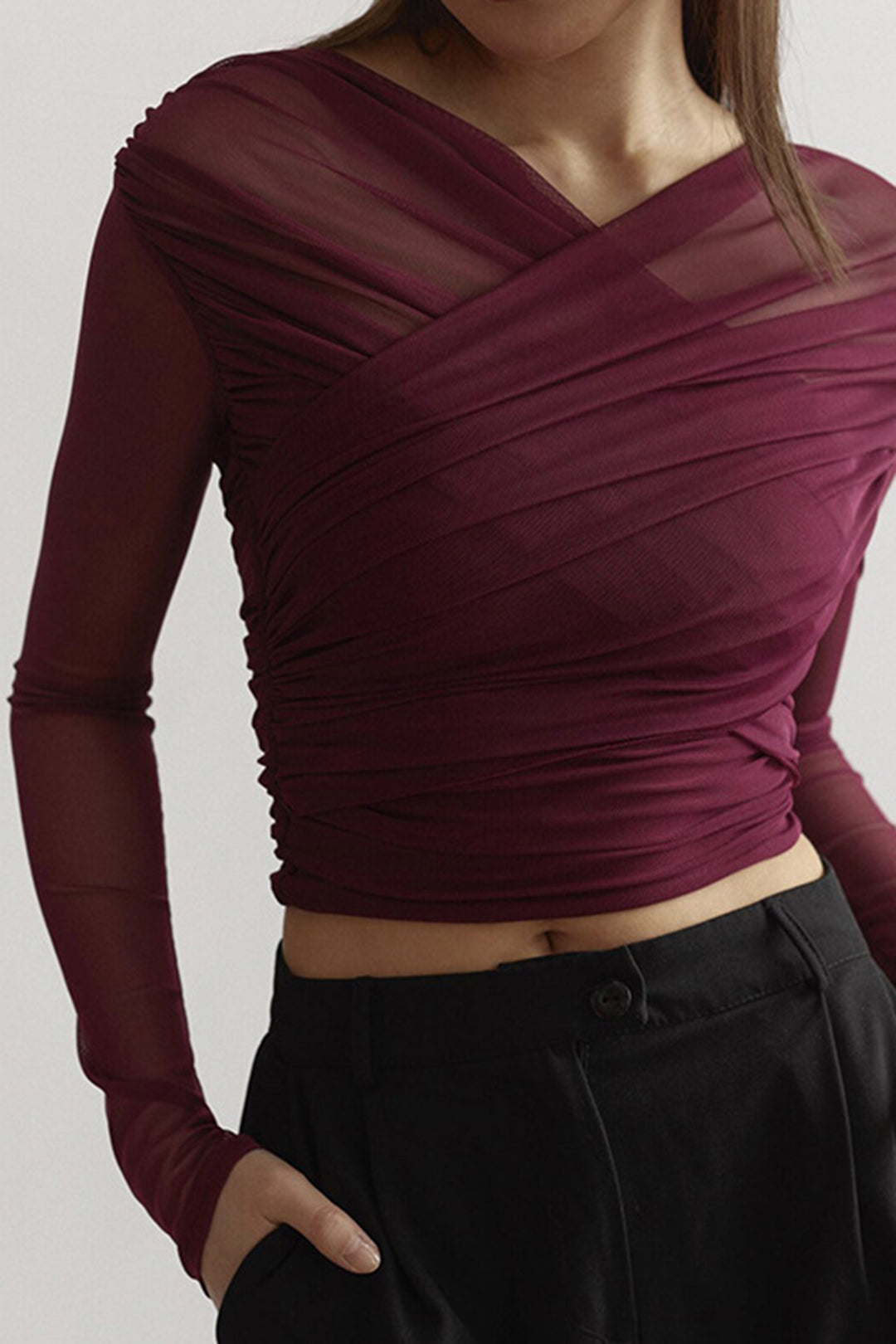 Trendy women's ruched mesh long sleeve top, ideal for a sophisticated party outfit.