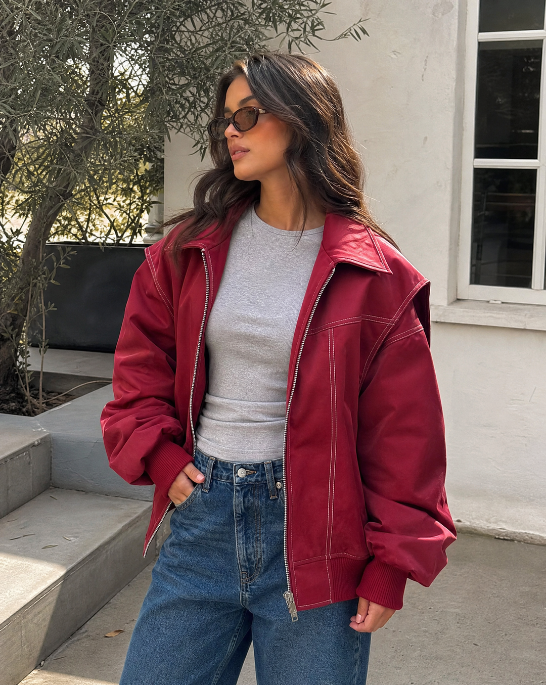 Women's oversized red zip-up bomber jacket with collar, trendy streetwear fashion.