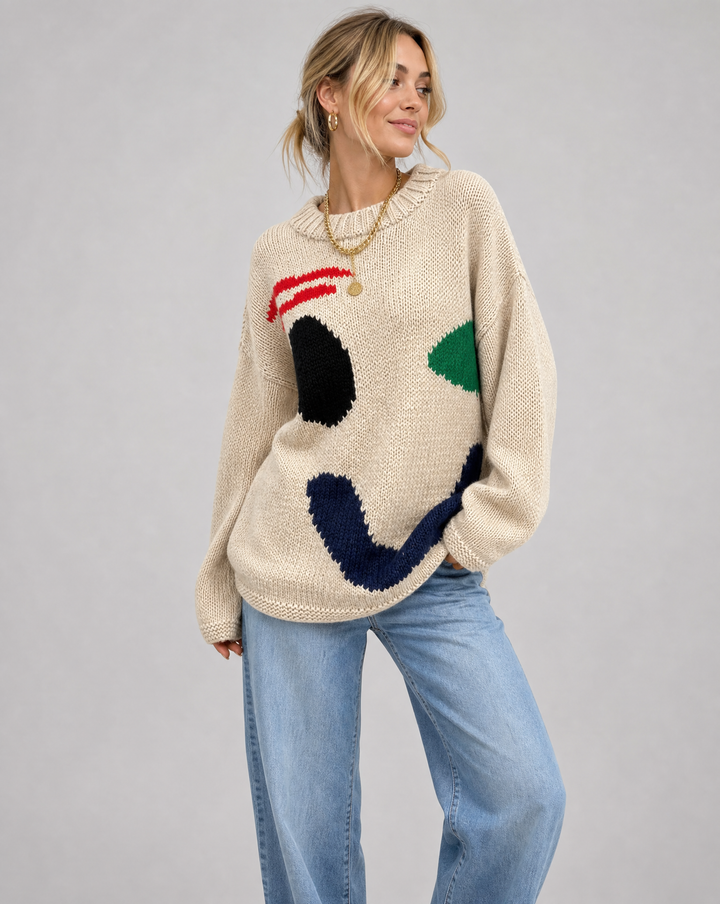 Women's oversized knit sweater with a bold smiley face, perfect for cozy and stylish casual wear.