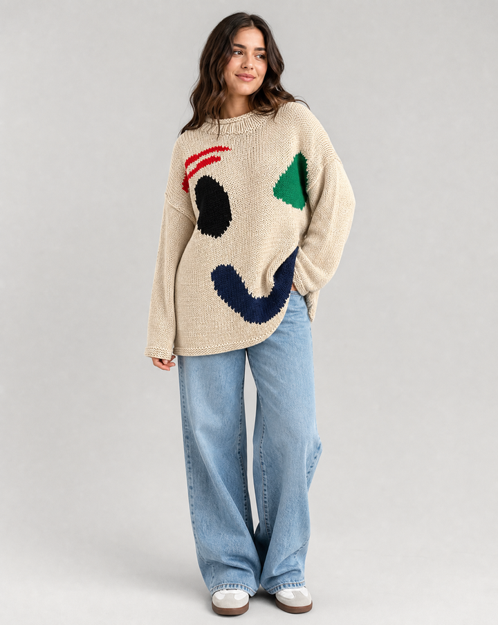 Fashionable women's oversized knit sweater with a large smiley face, great for casual winter style.