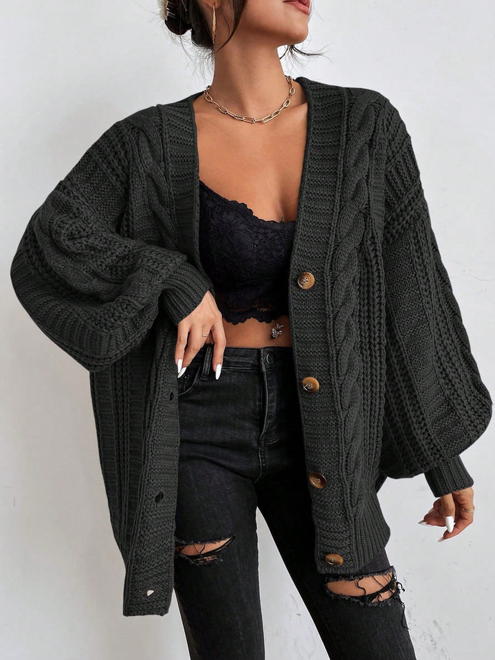 Soft women's oversized cable knit cardigan, offering a warm and comfortable fit for winter layering.