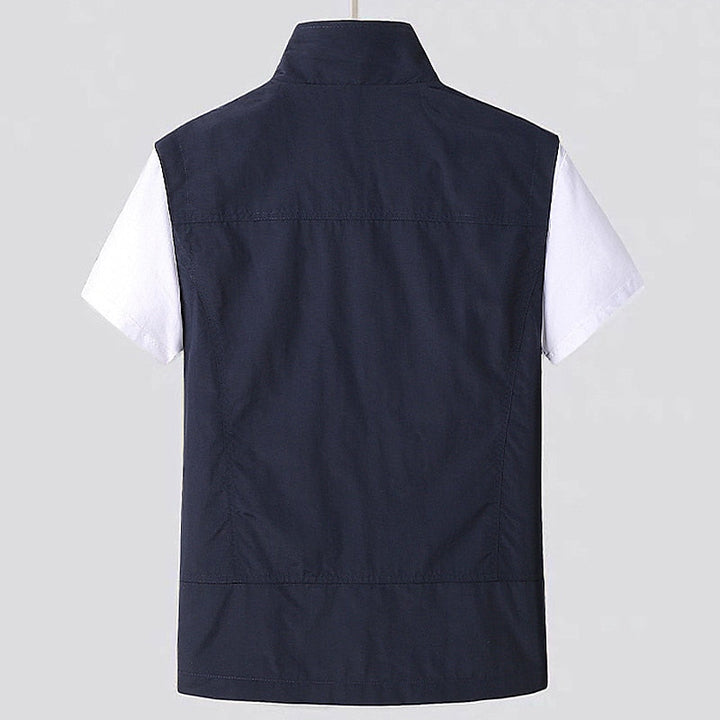 Men's lightweight travel vest featuring a water-repellent finish, full zip, and multiple utility pockets.