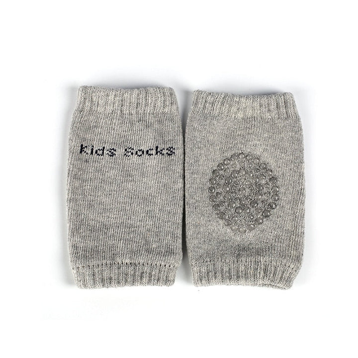 Happy baby crawling actively, protected by soft, non-slip knee pads for ultimate comfort & knee protection.