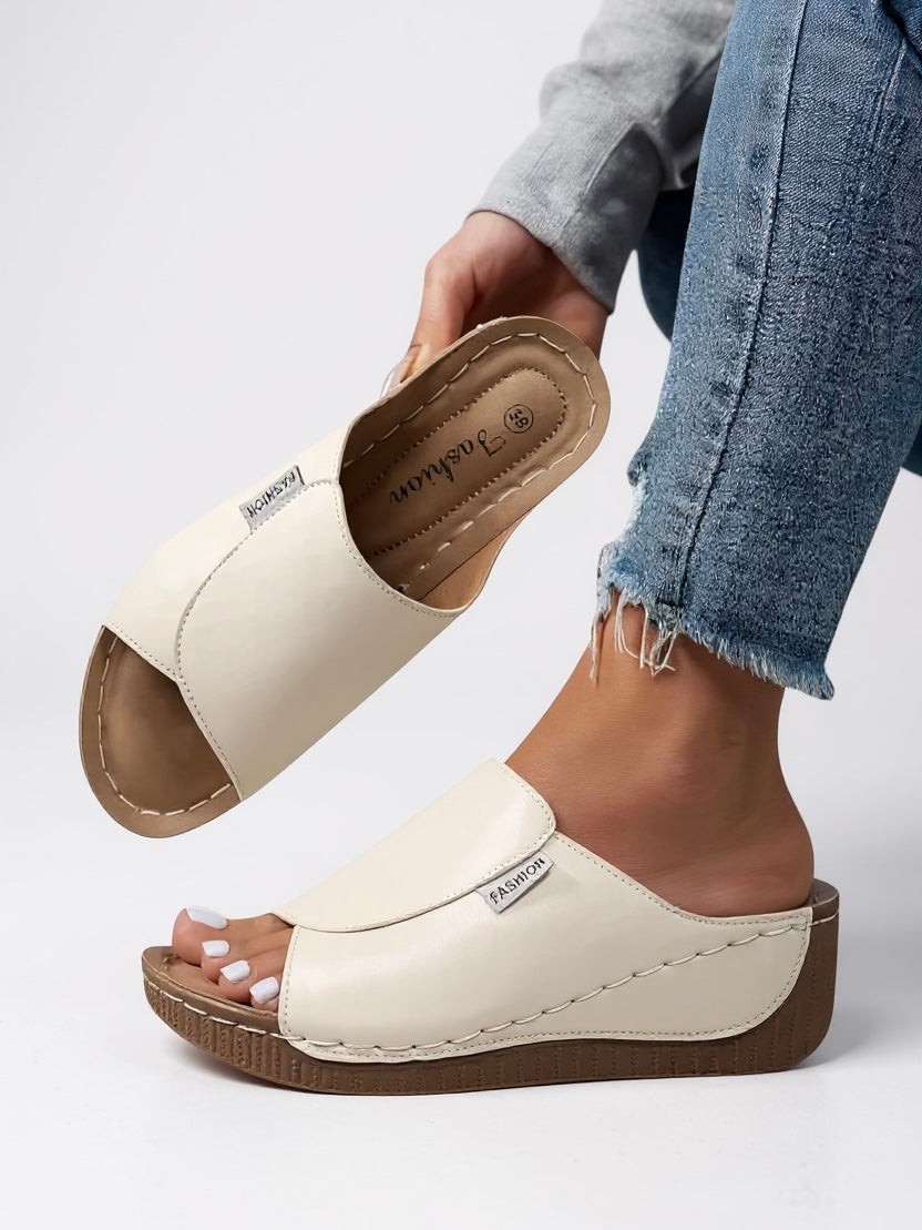 Trendy women's platform slide sandals, a comfortable minimalist choice for fashionable summer footwear.