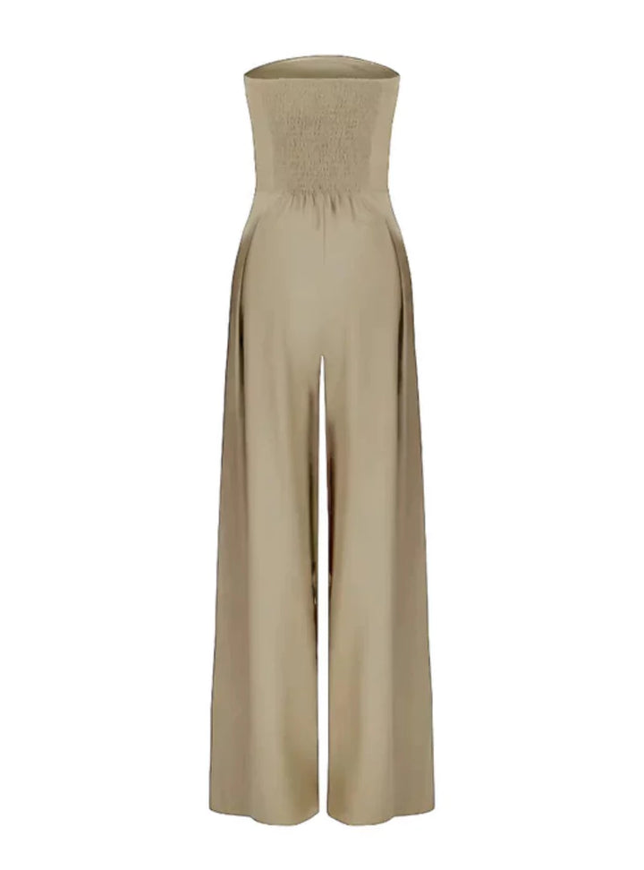 Woman models a chic strapless wide leg jumpsuit. Perfect for summer, this one-piece combines comfort & modern style.