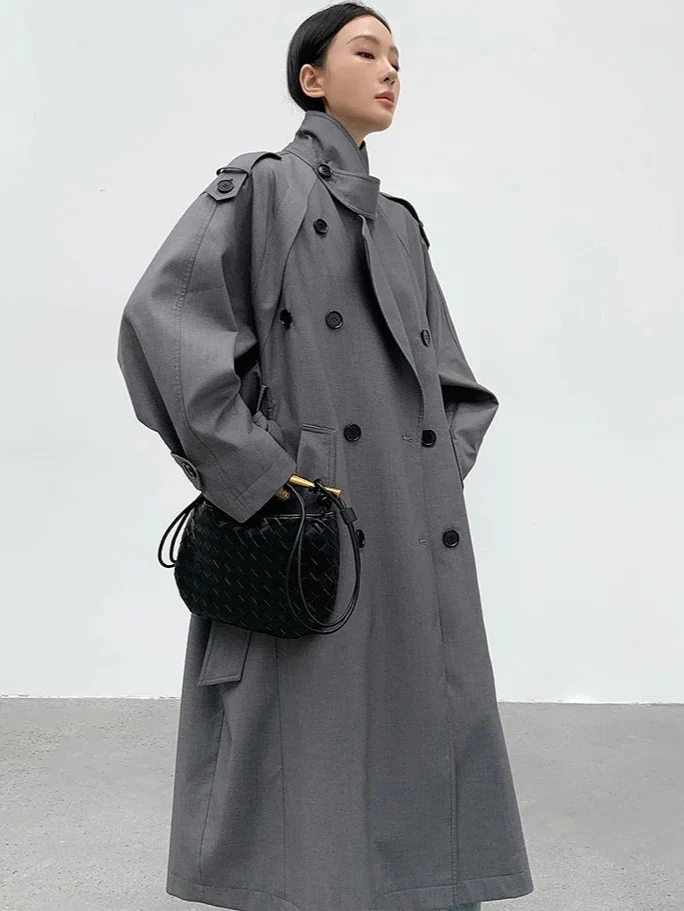Elegant women's double-breasted trench coat, long and oversized for a sophisticated fall fashion statement.