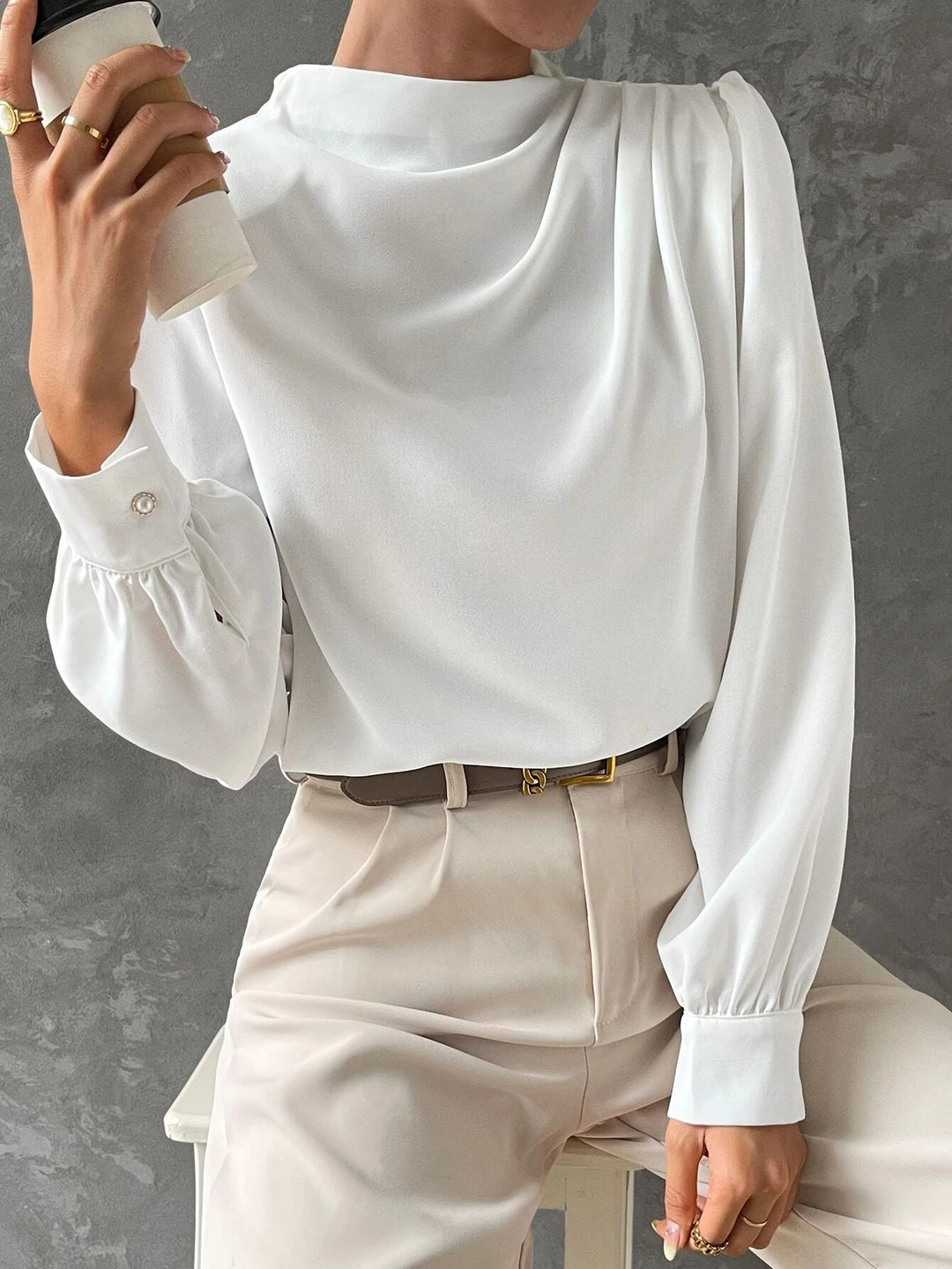 Elegant women's blouse featuring dramatic bishop sleeves and a graceful draped neckline. Versatile top.