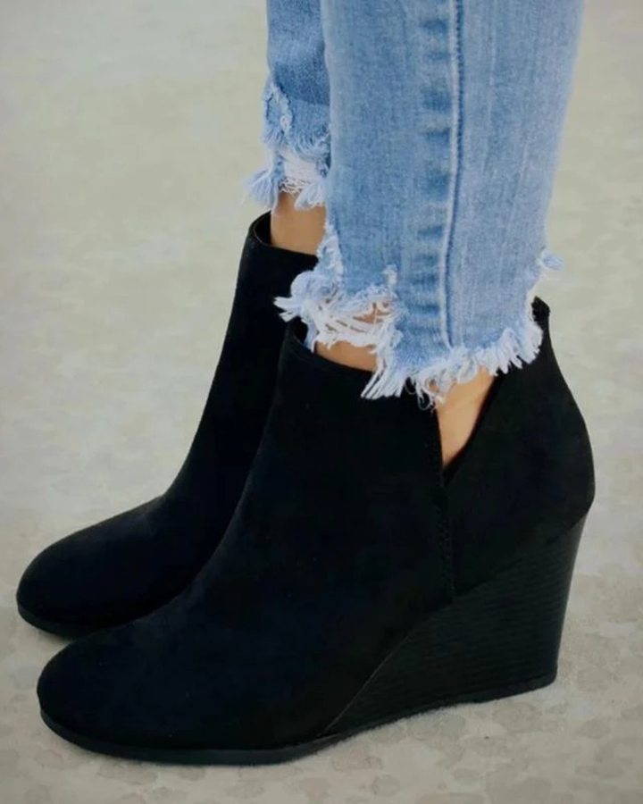 Stylish women's black wedge ankle boots with platform sole, designed for elevated comfort and everyday wear.