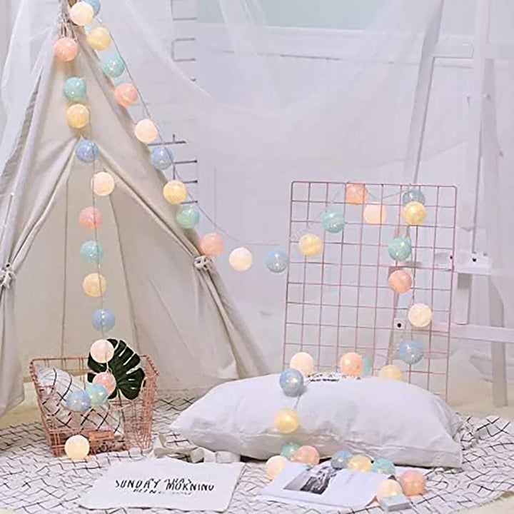 Cozy corner lit by warm LED cotton ball fairy lights, perfect for relaxation and ambiance.
