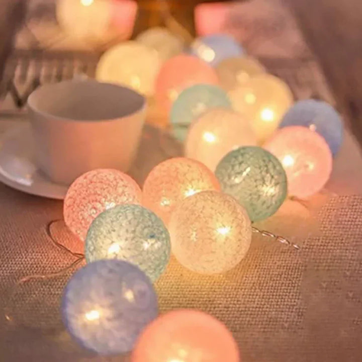 Warm LED cotton ball string lights draped elegantly, perfect for cozy room decor and ambiance.